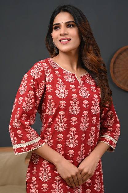 Woman wearing a red traditional outfit with white patterns on a dark background